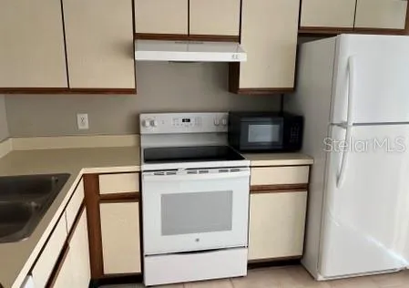 a kitchen with a refrigerator and a stove