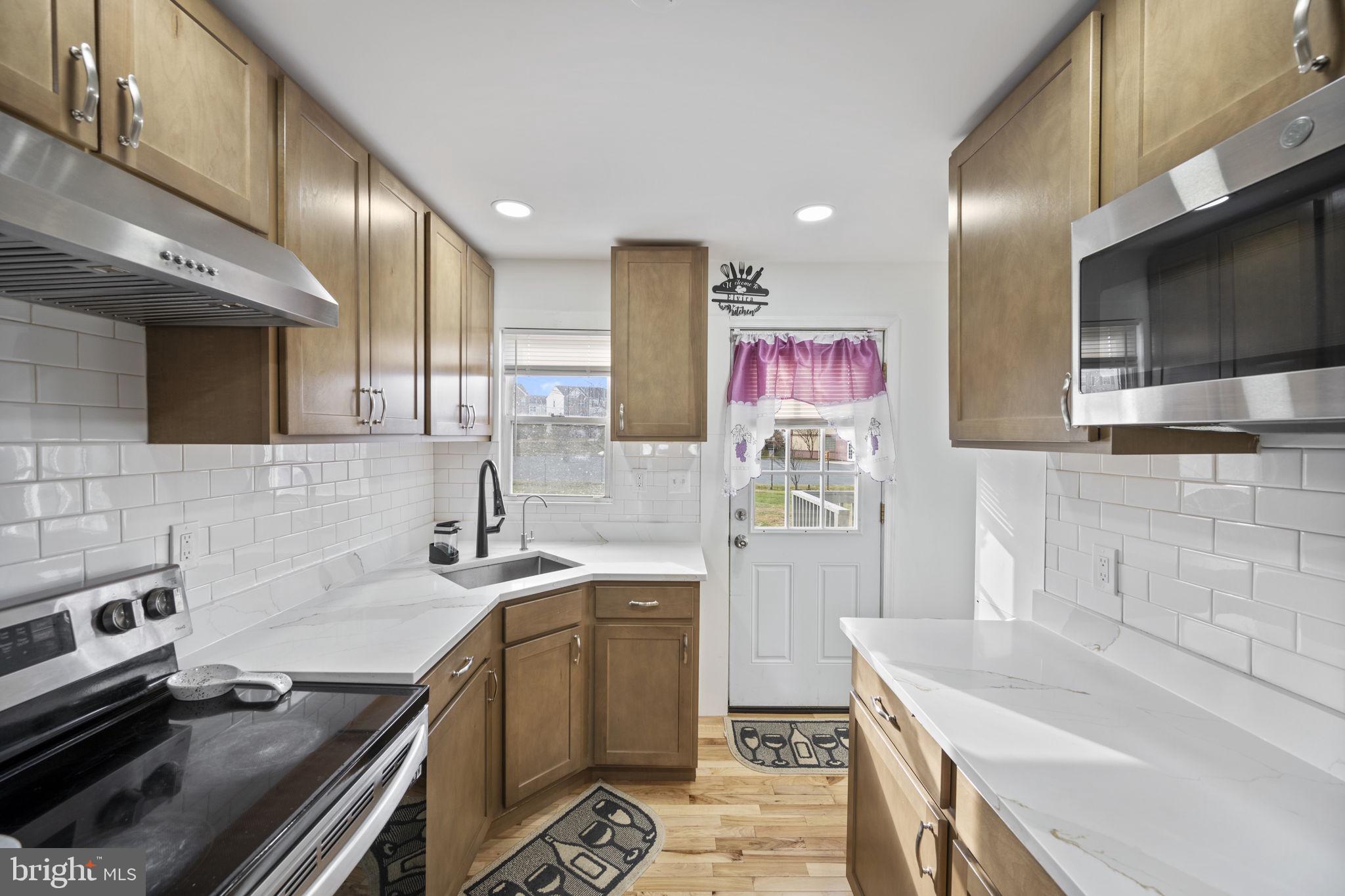7715 Old Battle Grove Road Dundalk, MD 21222 - Photo 11 of 61 a kitchen that has a sink and a stove in it