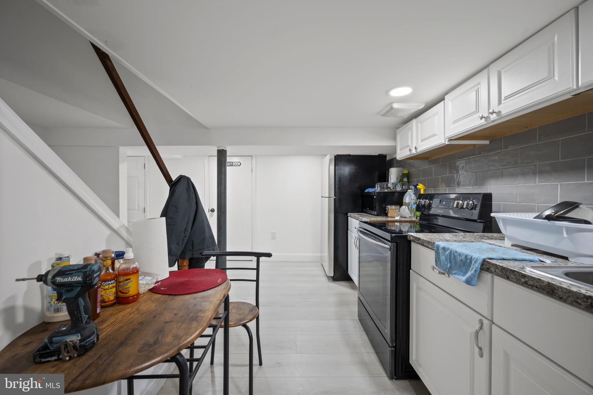 7715 Old Battle Grove Road Dundalk, MD 21222 - Photo 24 of 61 a kitchen with a sink a stove and chairs