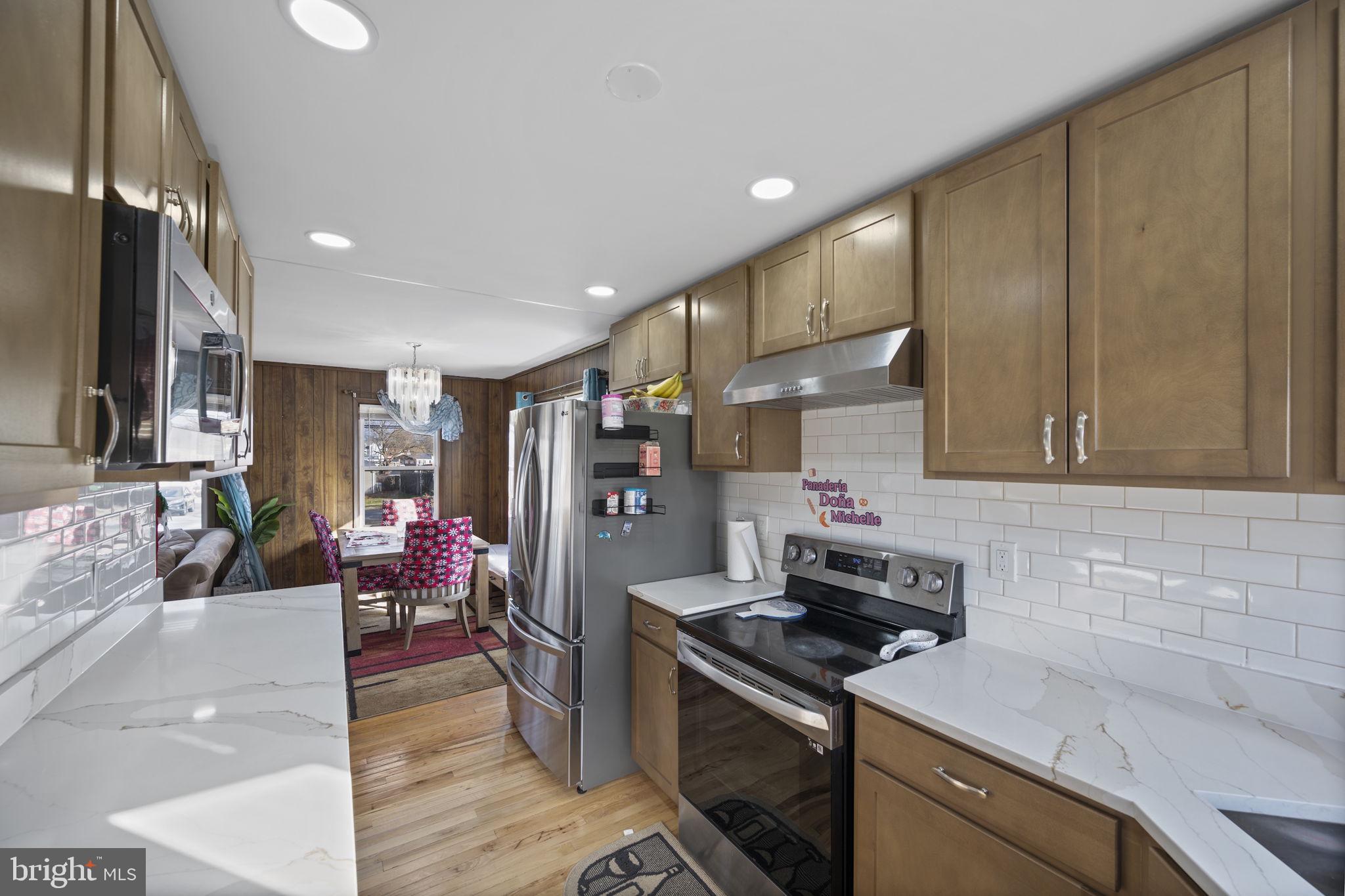 7715 Old Battle Grove Road Dundalk, MD 21222 - Photo 9 of 61 a kitchen with stainless steel appliances granite countertop a stove a sink and a refrigerator