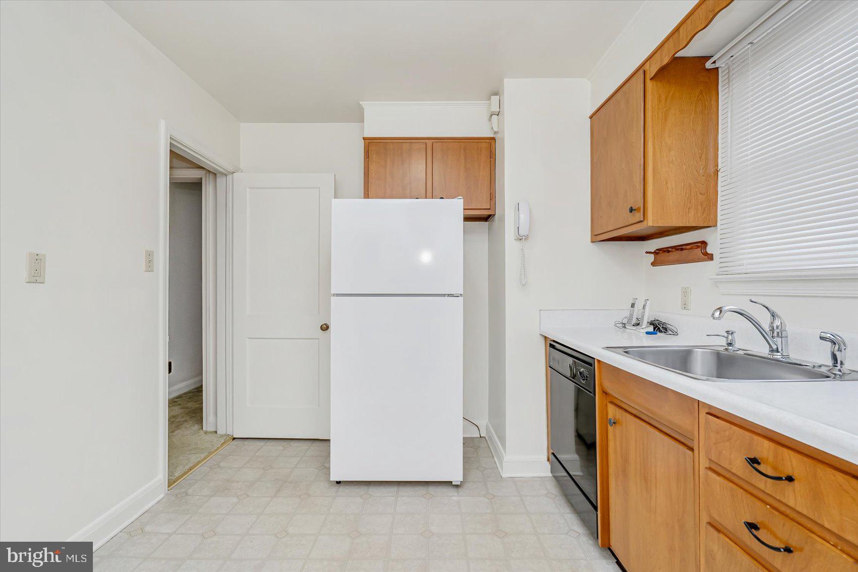 1528 Leslie Road Baltimore, MD 21222 - Photo 12 of 33 a kitchen with a sink and a refrigerator