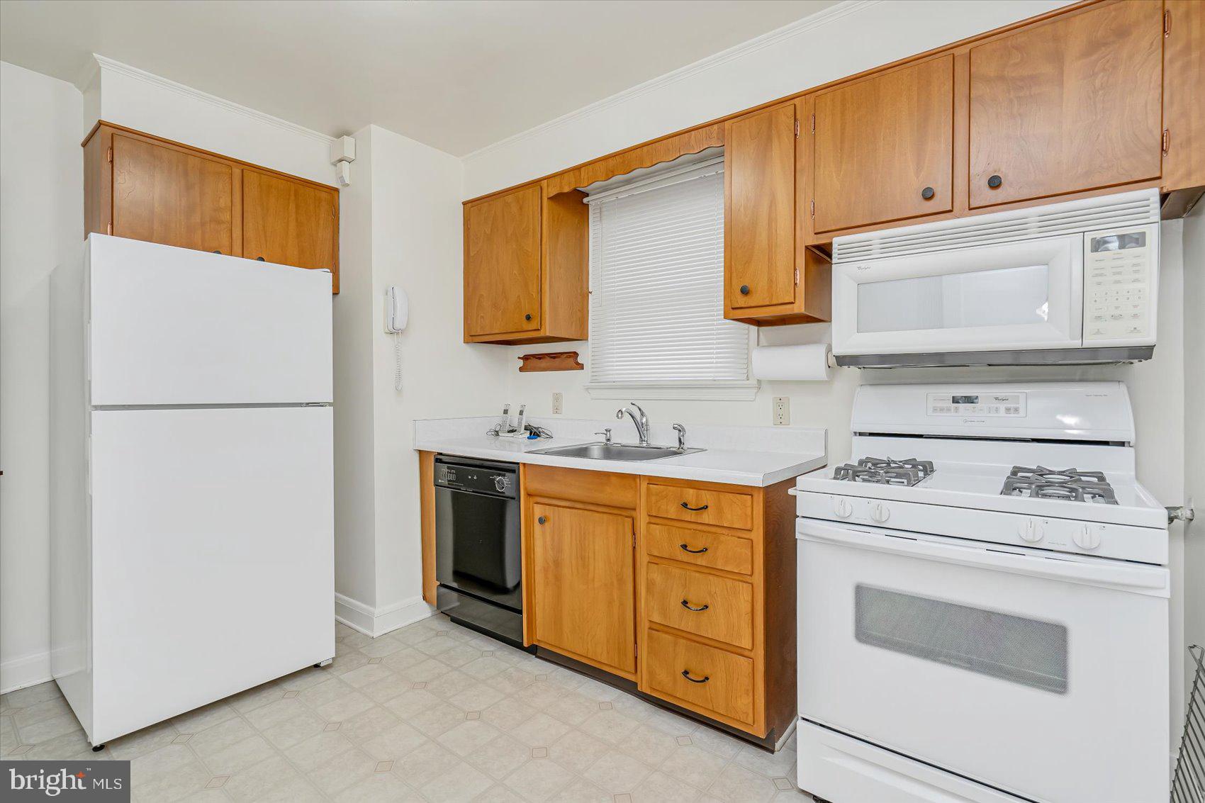 1528 Leslie Road Baltimore, MD 21222 - Photo 10 of 33 a kitchen with stainless steel appliances granite countertop a stove a refrigerator and a sink with cabinets
