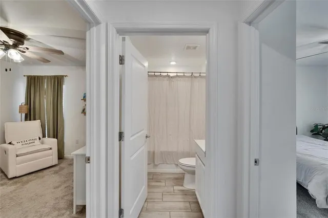 a bedroom with a bed and a ceiling fan