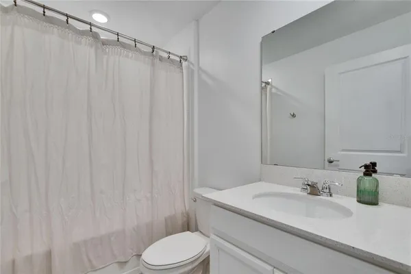 a view of a bedroom with furniture and fan