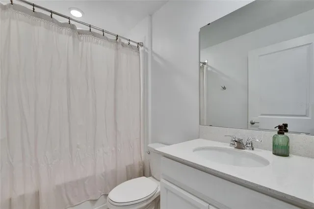 a view of a bedroom with furniture and fan