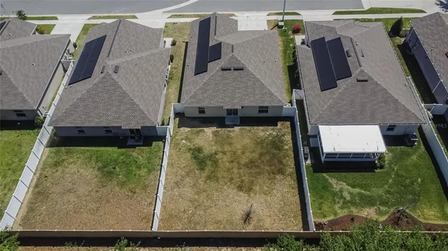 an aerial view of residential houses with outdoor space and parking