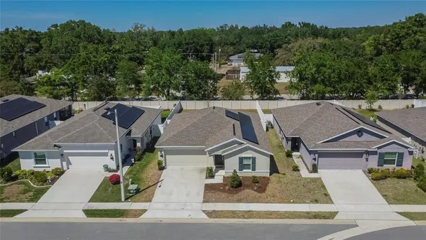 an aerial view of residential houses with outdoor space and swimming pool