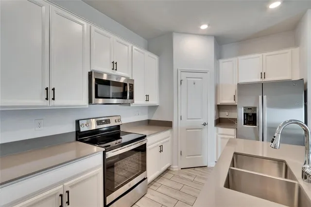 a kitchen with white cabinets and stainless steel appliances