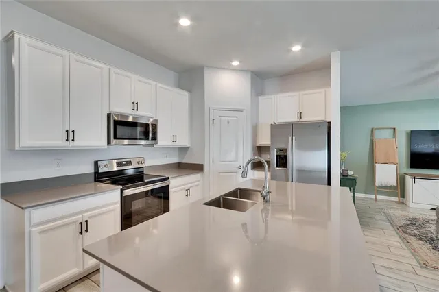 a kitchen with white cabinets and stainless steel appliances