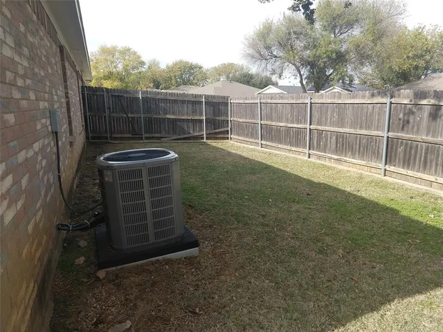 a view of back yard with wooden fence