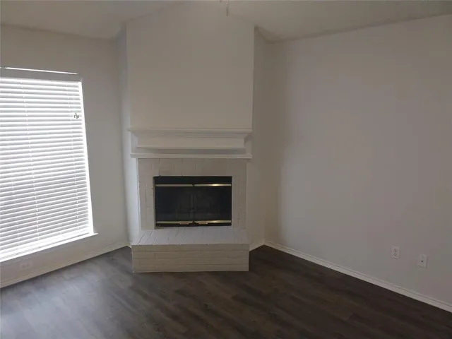 an empty room with wooden floor and a fireplace