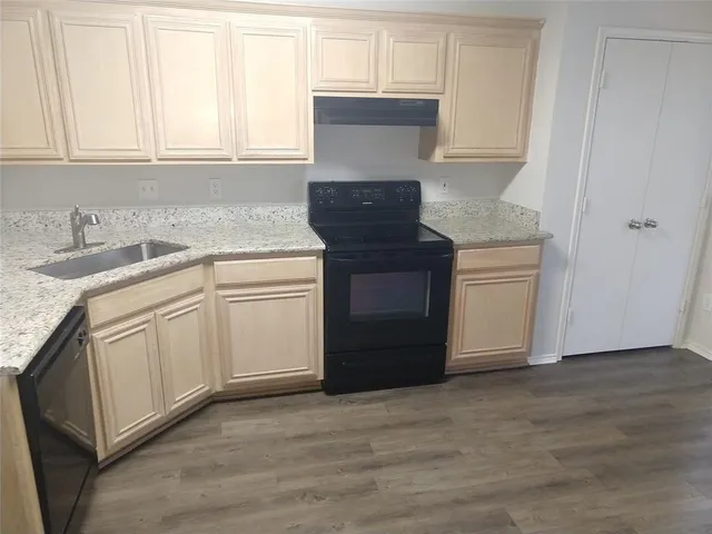 a kitchen with granite countertop white cabinets and sink