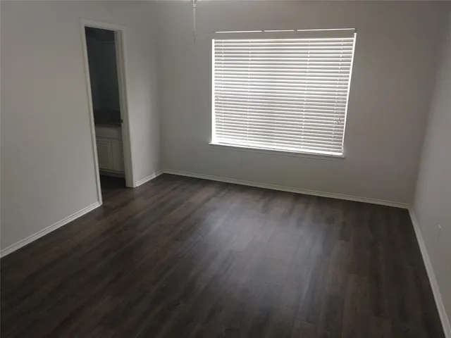 an empty room with wooden floor and a window