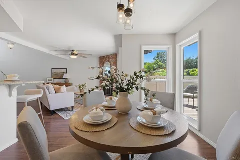 a dining room with furniture and a potted plant