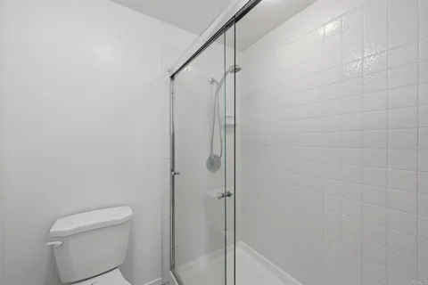 a bathroom with a shower a toilet and a sink