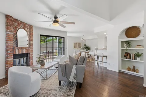 a living room with fireplace furniture and a large window