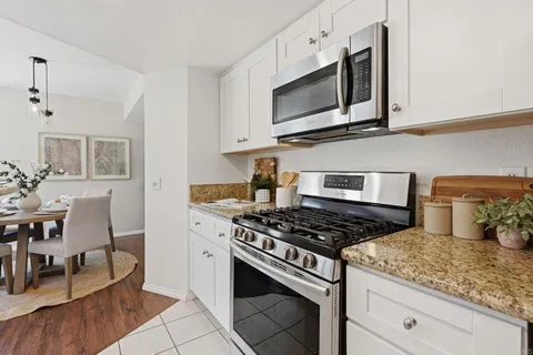 a kitchen with granite countertop stainless steel appliances a stove cabinets and microwave