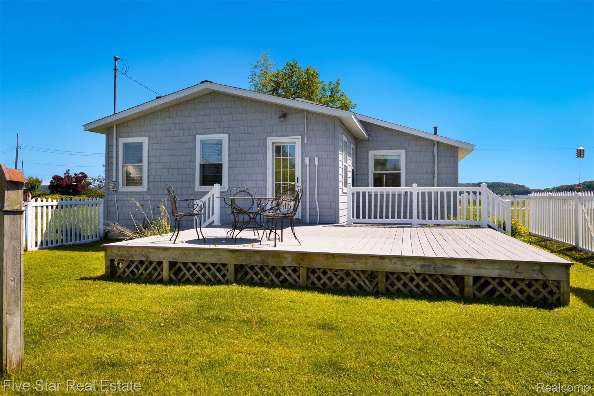 2588 Lakeview Road Onekama, MI 49675 - Photo 25 of 32 Exterior featuring yard & a white vinyl picket fence