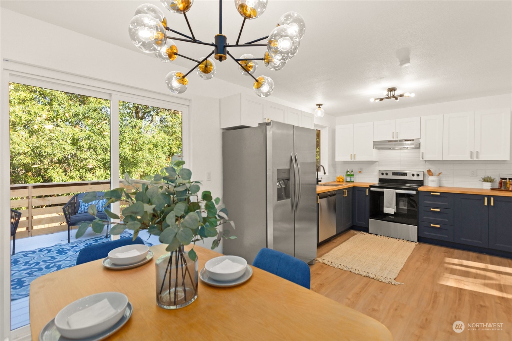 22612 20th Avenue Southeast Bothell, WA 98021 - Photo 13 of 35 a kitchen with stainless steel appliances granite countertop a refrigerator a sink a stove and a dining table with wooden floor