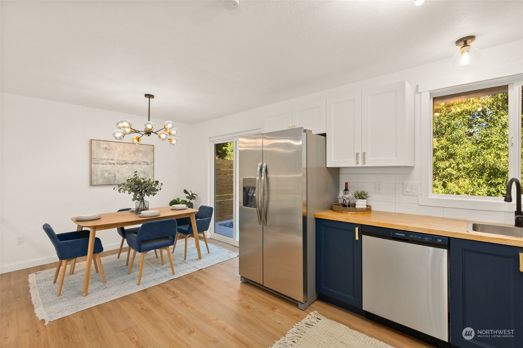 22612 20th Avenue Southeast Bothell, WA 98021 - Photo 10 of 35 a kitchen with stainless steel appliances granite countertop a refrigerator a sink dishwasher a dining table and chairs with wooden floor