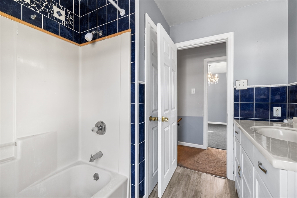 22 Pleasant Street, Unit D Lawrence, MA 01841 - Photo 16 of 32 a bathroom with a tub a sink a mirror and a shower