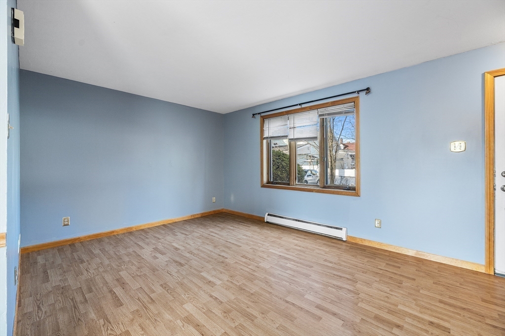 22 Pleasant Street, Unit D Lawrence, MA 01841 - Photo 5 of 32 a view of an empty room with window and wooden floor