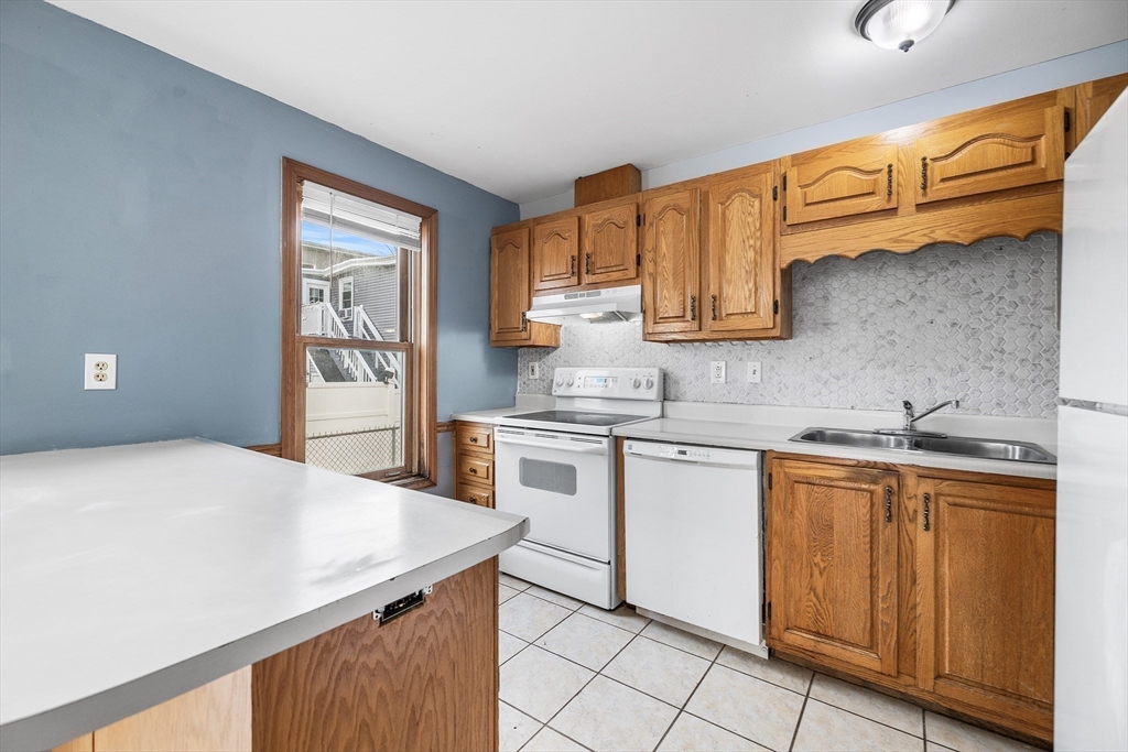 22 Pleasant Street, Unit D Lawrence, MA 01841 - Photo 8 of 32 a kitchen with stainless steel appliances granite countertop a sink and cabinets