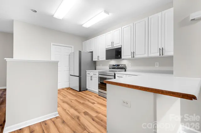 a kitchen with white cabinets and stainless steel appliances