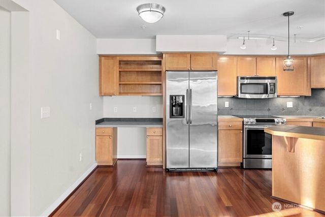a kitchen with stainless steel appliances a refrigerator and a stove top oven