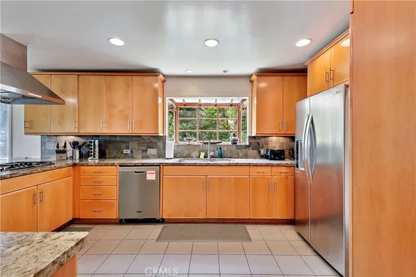 a kitchen with stainless steel appliances granite countertop sink stove and large window