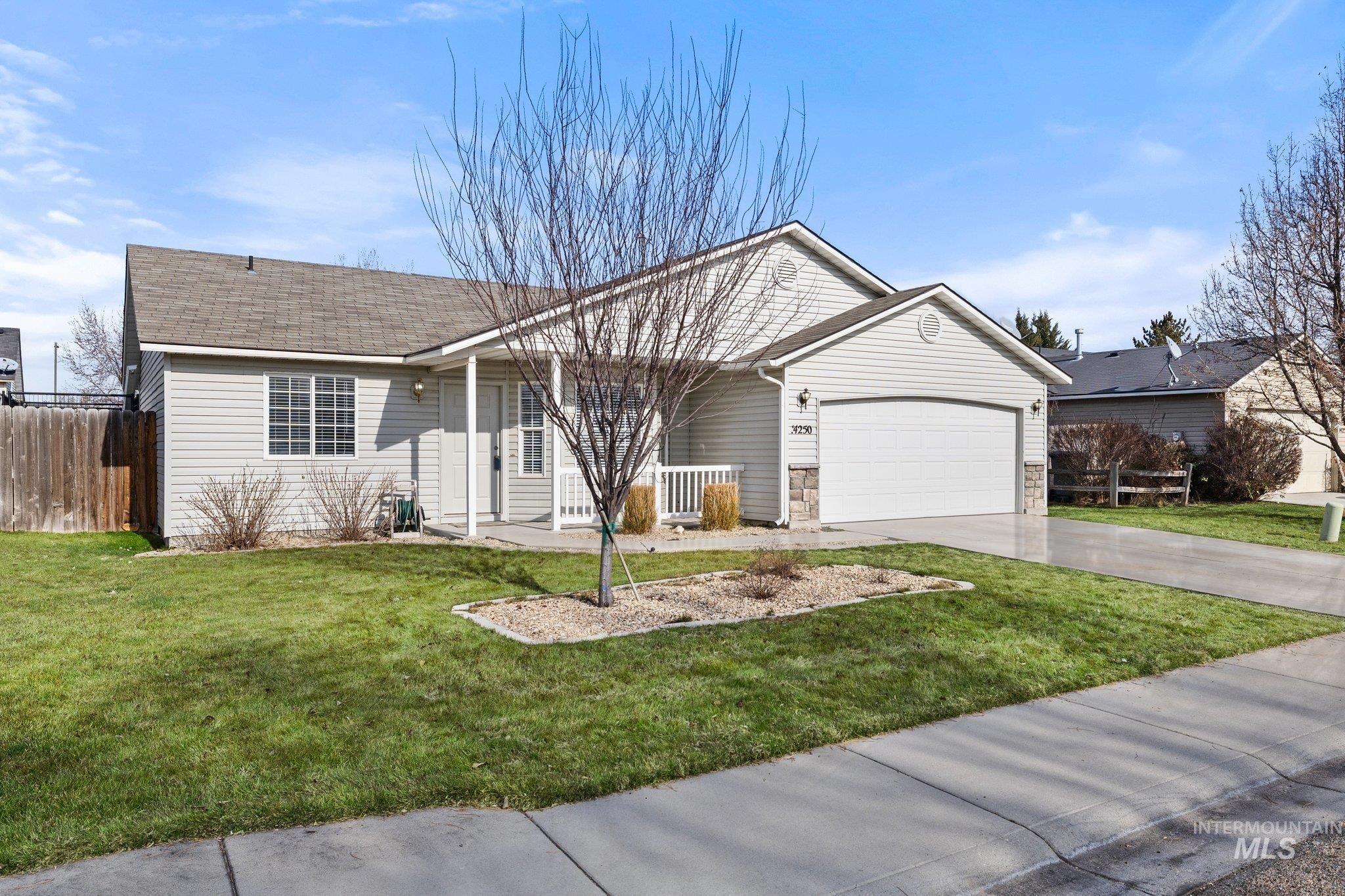 Single story home featuring driveway, an attached garage, covered porch, and a shingled roof