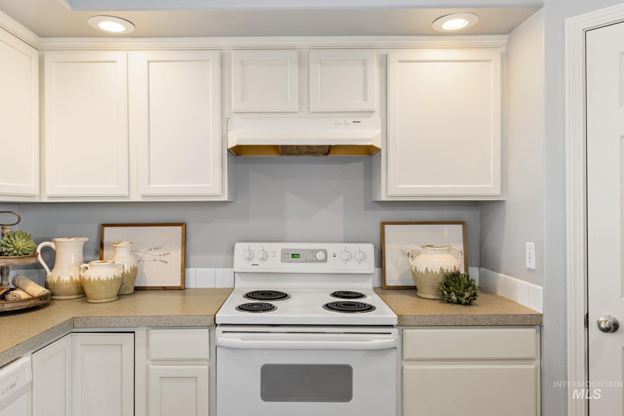 14250 Blue Ridge Street Caldwell, ID 83607 - Photo 11 of 33 Kitchen with white appliances, white cabinets, recessed lighting, and light countertops