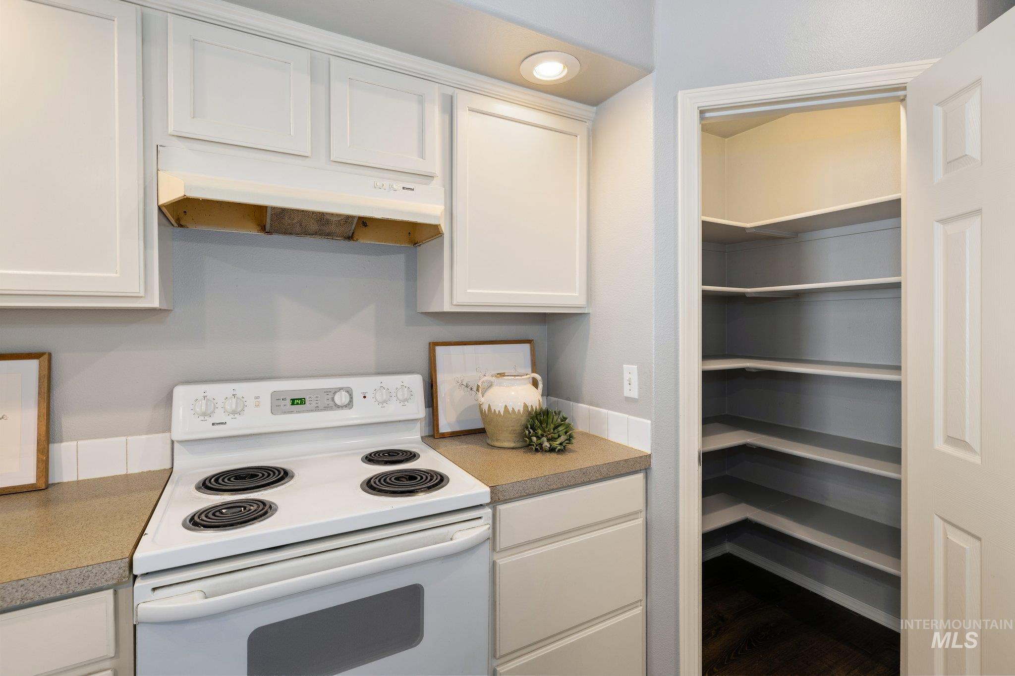 14250 Blue Ridge Street Caldwell, ID 83607 - Photo 12 of 33 Kitchen featuring electric range, white cabinetry, and light countertops