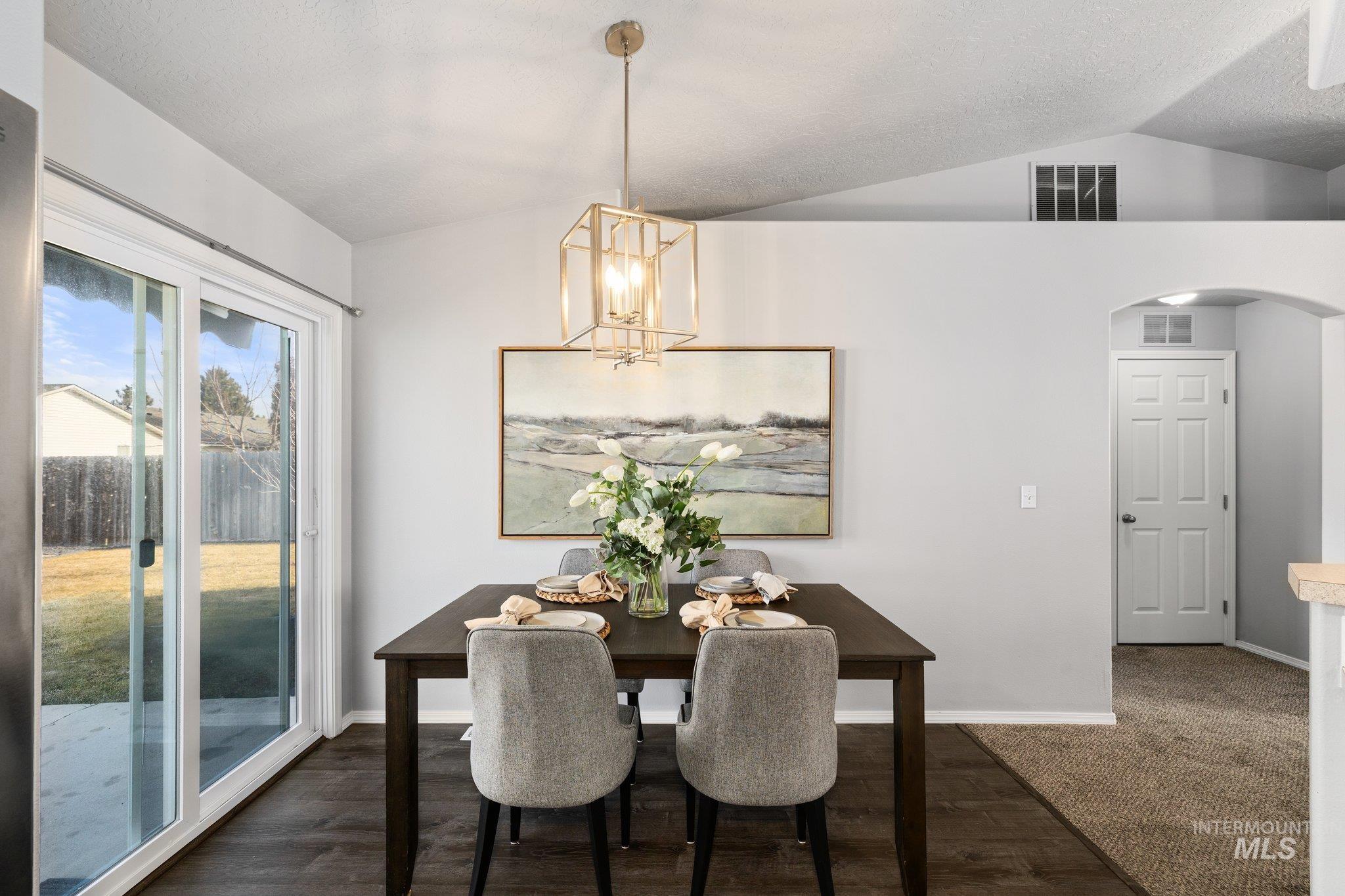 14250 Blue Ridge Street Caldwell, ID 83607 - Photo 15 of 33 Dining area with arched walkways, dark wood-style floors, and hanging lights