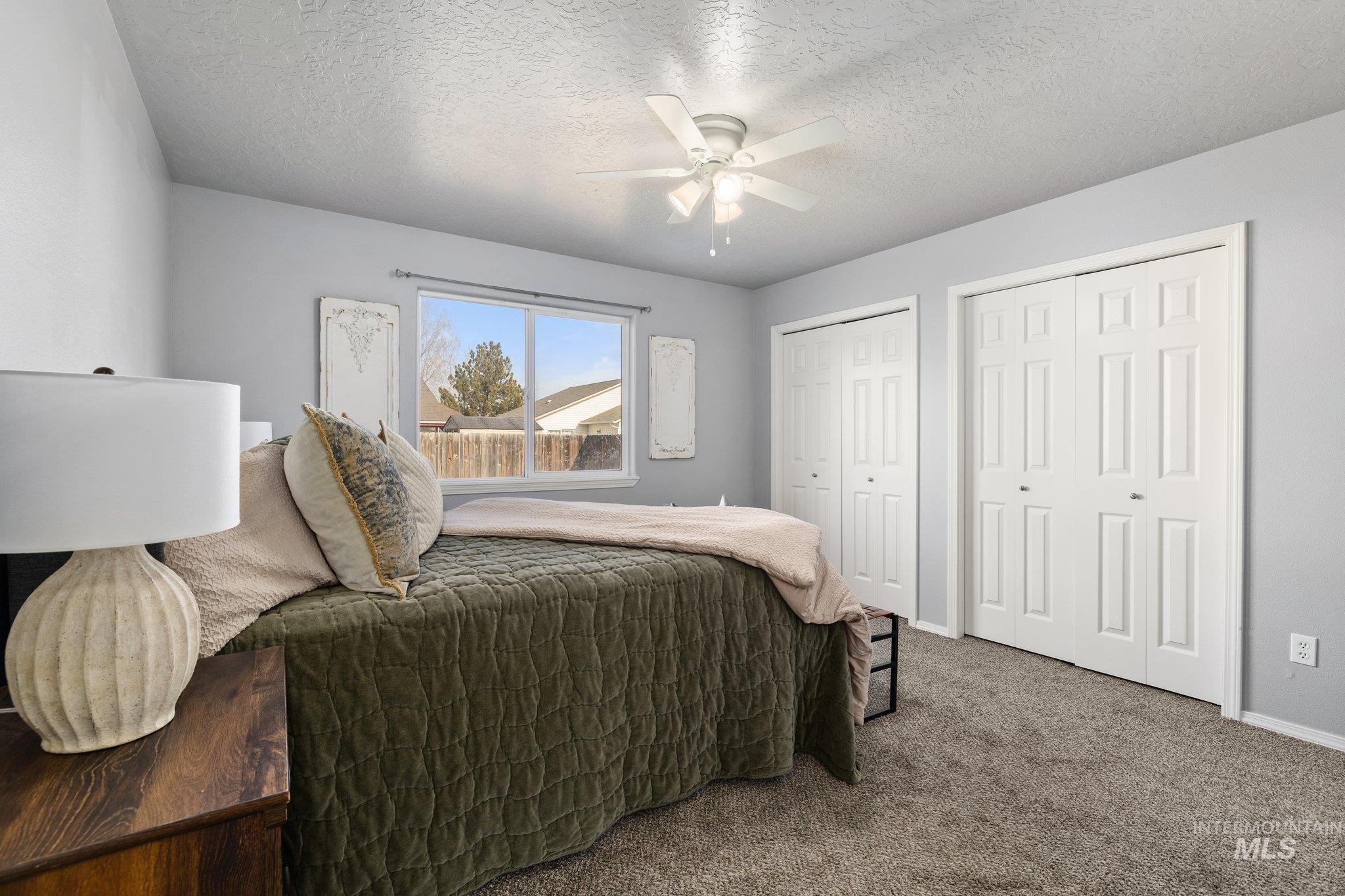 14250 Blue Ridge Street Caldwell, ID 83607 - Photo 17 of 33 Bedroom featuring carpet, multiple closets, ceiling fan, and a textured ceiling