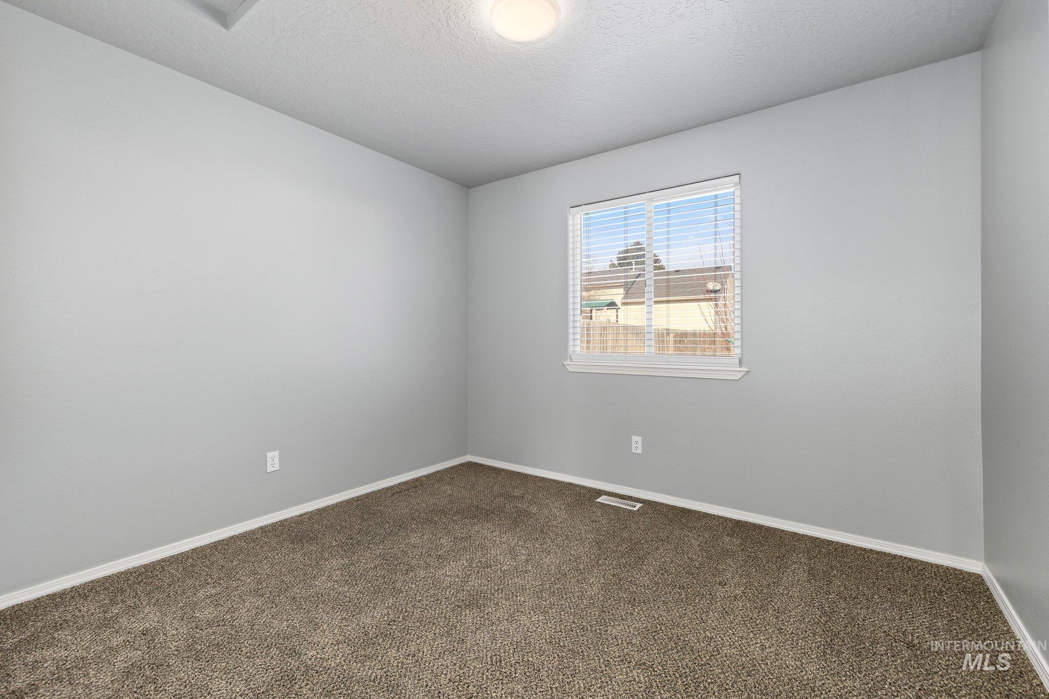 14250 Blue Ridge Street Caldwell, ID 83607 - Photo 21 of 33 Carpeted spare room with baseboards and a textured ceiling