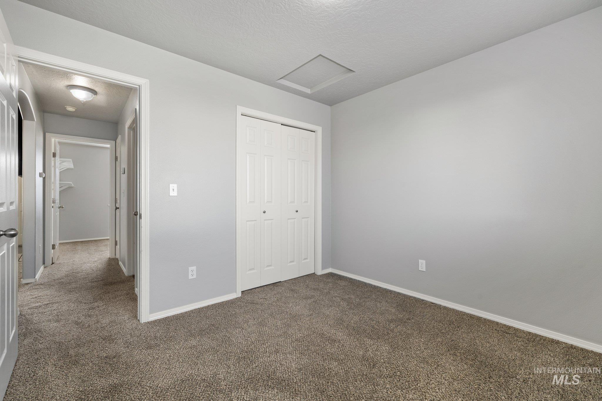 14250 Blue Ridge Street Caldwell, ID 83607 - Photo 22 of 33 Unfurnished bedroom featuring carpet, a closet, and a textured ceiling