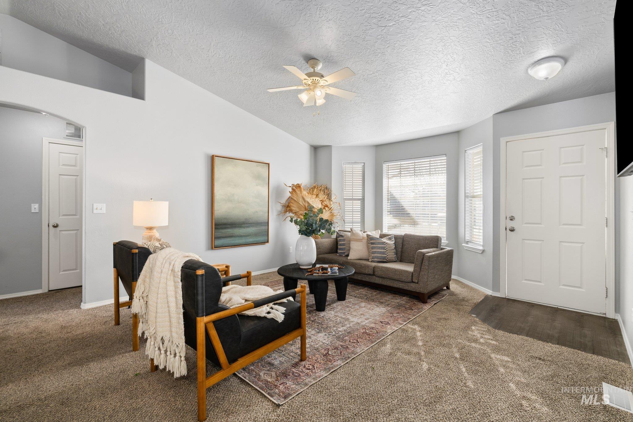 14250 Blue Ridge Street Caldwell, ID 83607 - Photo 3 of 33 Living area featuring ceiling fan, carpet floors, and arched walkways