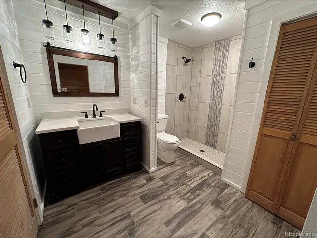 a spacious bathroom with a double vanity sink toilet and shower