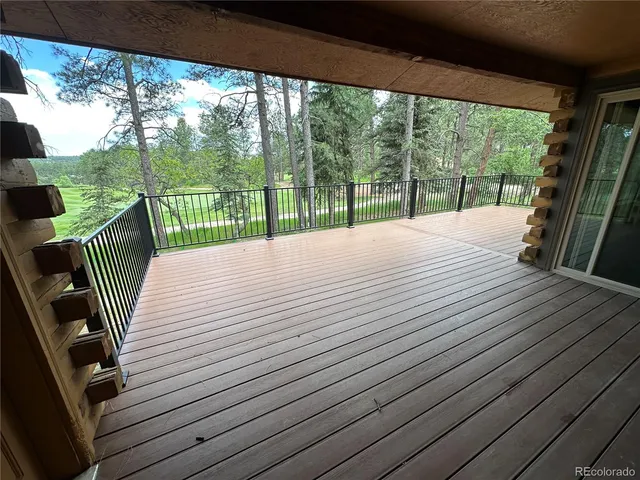 a balcony with view of balcony with wooden floor and fence