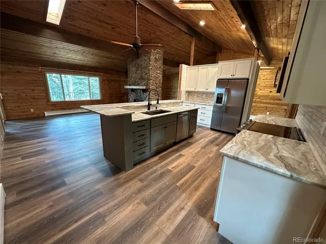 a large kitchen with wooden floors and a sink