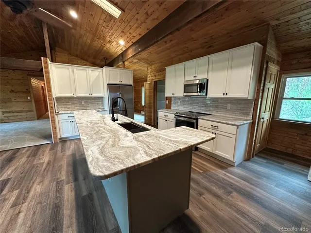 a kitchen with stainless steel appliances granite countertop a sink stove and cabinets