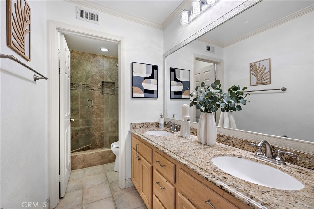 11625 Allen Tustin, CA 92782 - Photo 32 of 45 a bathroom with a granite countertop sink a mirror and a shower