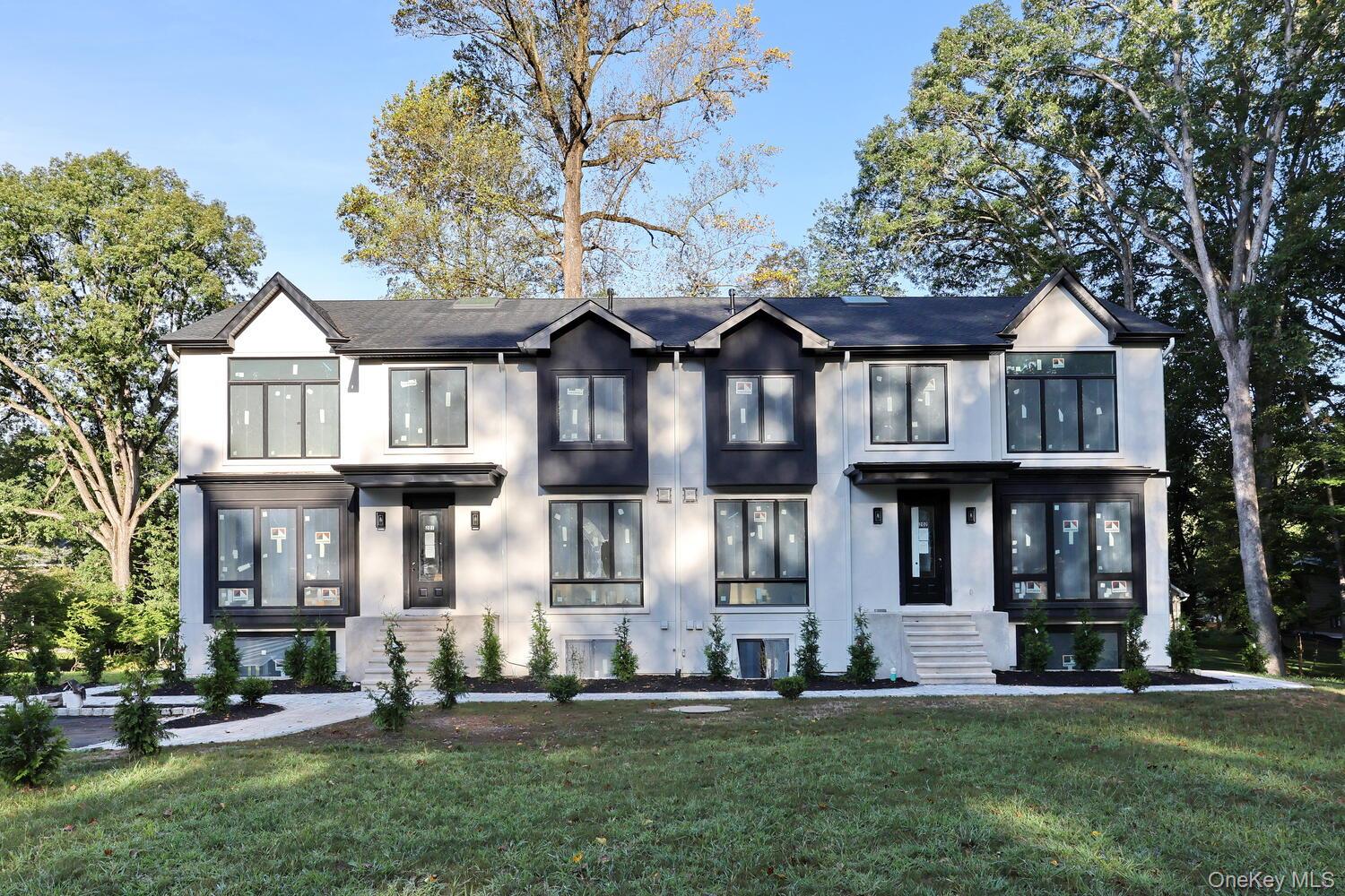 View of front facade with stucco siding and a front lawn