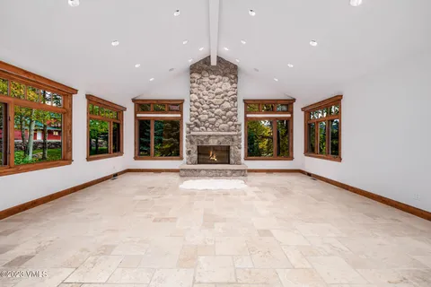 a view of an empty room with a fireplace and a window