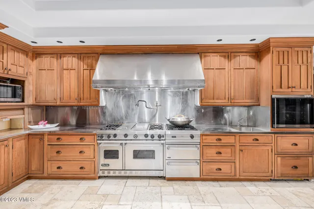 a kitchen with granite countertop a sink stainless steel appliances and cabinets