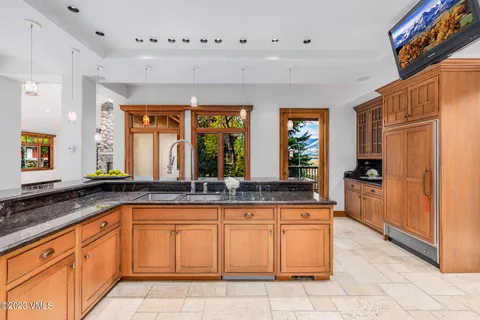a large kitchen with granite countertop a large counter top space and stainless steel appliances