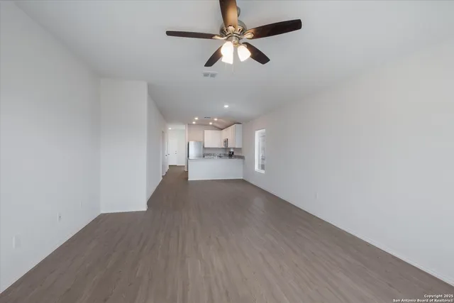 a view of an empty room with a kitchen