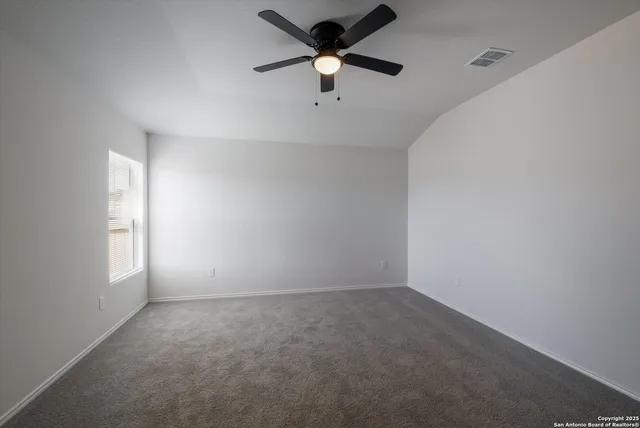 an empty room with a window and a fan