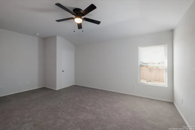 an empty room with a window and a fan